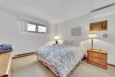 a bedroom with a bed and a dresser and two lamps at Lakefront Views 5 Bdrm Kayaks Out Kitchen in Lake Ariel