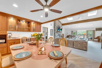 a dining room with a table and a kitchen at Lakefront Views 5 Bdrm Kayaks Out Kitchen in Lake Ariel