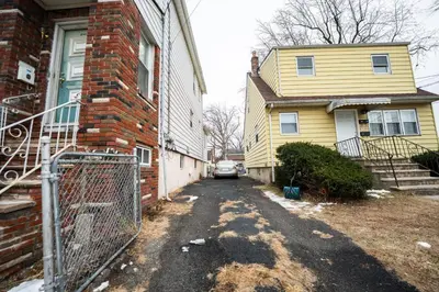 an alley between two houses with a car parked in the driveway at Linden Room in Linden