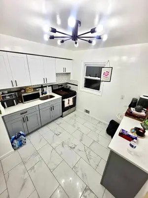a kitchen with white cabinets and a ceiling fan at Linden Room in Linden