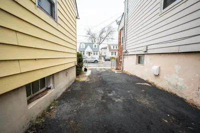 an alley between two buildings next to a house at Linden Room in Linden