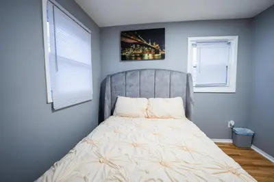 a bed in a bedroom with two windows at Linden Room in Linden