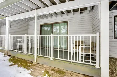 a screened porch with a white railing on a house at All-Season Lake Wallenpaupack Condo with Views in Greentown