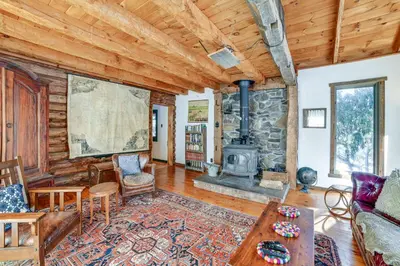 a living room with a fireplace and a stone wall at Family Cabin Near Bellayre and Plattekill Mtns! in Andes