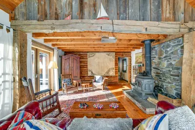 a living room with a fireplace and a stone wall at Family Cabin Near Bellayre and Plattekill Mtns! in Andes