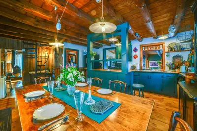 a dining room with a wooden table and blue walls at Family Cabin Near Bellayre and Plattekill Mtns! in Andes