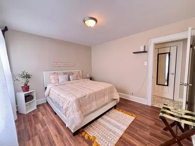 a bedroom with a large bed and a wooden floor at Perfect full private first floor home with convenient amenities in Union