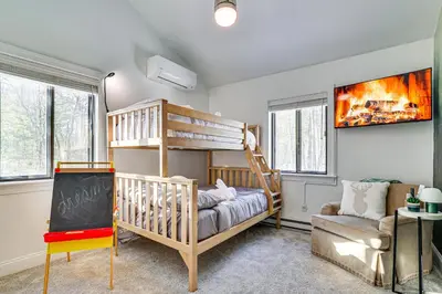 a childs room with a bunk bed and a couch at Lake Naomi Luxury Home with Stream Pool and Fire Pit in Pocono Pines