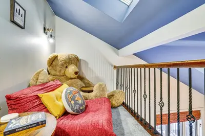 a teddy bear sitting on a bed in a room at Lake Naomi Luxury Home with Stream Pool and Fire Pit in Pocono Pines