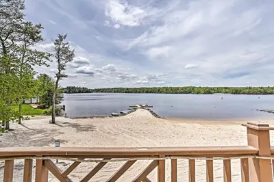 a view of a beach with a wooden fence at Lake Naomi Luxury Home with Stream Pool and Fire Pit in Pocono Pines