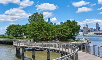 a bridge over the water with a city in the background at New Cozy Must Have Stay! 10 minutes to NYC in Hoboken