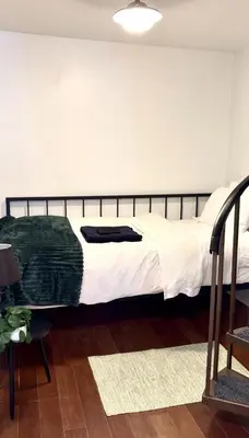 a bedroom with a large bed with white sheets at New Cozy Must Have Stay! 10 minutes to NYC in Hoboken