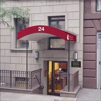 a store entrance with a red canopy in front of a building at Synergy Madison in New York