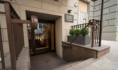 a door to a store with a potted plant in front at Synergy Madison in New York