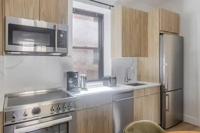 a kitchen with stainless steel appliances and a microwave at Blueground Murray Hill view nr Empire State NYC-1911 in New York