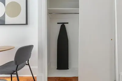 a black surfboard hanging on a wall next to a chair at Blueground Alphabet City washer nr Tompkins Square Park NYC-2161 in New York