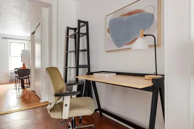 a desk with a lamp and a chair in a room at Blueground Alphabet City washer nr Tompkins Square Park NYC-2161 in New York