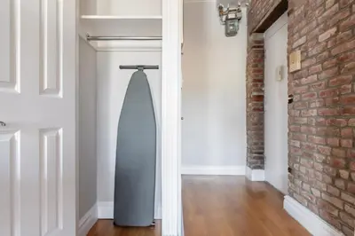 a surfboard hanging in a room with a brick wall at Blueground Nolita view nr Washington Square NYC-2051 in New York