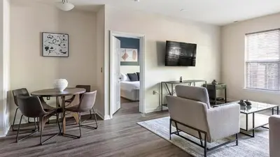 a living room with a table and chairs and a bedroom at Landing Beautiful 2BD Pool Clubhouse in King of Prussia