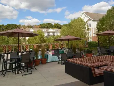 a patio with tables and chairs and umbrellas at Landing Beautiful 2BD Pool Clubhouse in King of Prussia