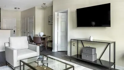 a living room with a chair and a television on a wall at Landing Beautiful 2BD Pool Clubhouse in King of Prussia