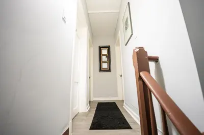 a hallway with white walls and a black rug at Casa Ebenecer - Habitación privada # 3 in Elizabeth