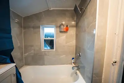 a bathroom with a white tub and a window at Casa Ebenecer - Habitación privada # 3 in Elizabeth