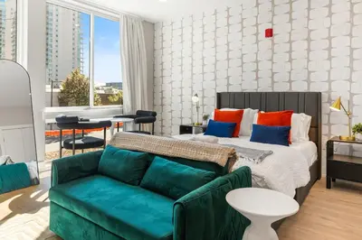 a living room with a bed and a couch at Lux Studio Apt - Rooftop - 5 mins to The Fillmore in Philadelphia