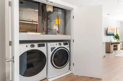a laundry room with a washer and dryer at Lux Studio Apt - Rooftop - 5 mins to The Fillmore in Philadelphia