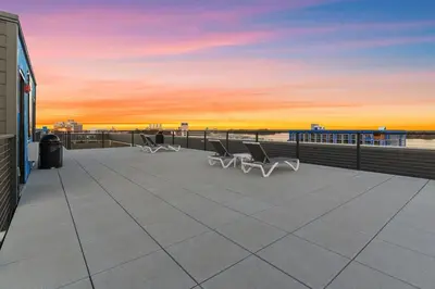 a patio with chairs and a sunset in the background at Lux Studio Apt - Rooftop - 5 mins to The Fillmore in Philadelphia