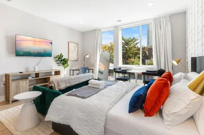 a bedroom with a large bed and a living room at Lux Studio Apt - Rooftop - 5 mins to The Fillmore in Philadelphia
