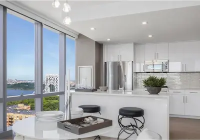 a kitchen with white cabinets and a large window at Everlasting Reality in Fort Lee