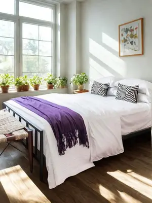 a bedroom with a large bed with a purple blanket on it at Everlasting Reality in Fort Lee