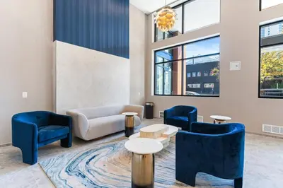 a lobby with blue chairs and a couch and tables at 1 bed APT - located next to center city in Philadelphia