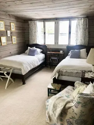 a bedroom with two beds and a couch and windows at Holly Cottage Quaker Lake in Brackney