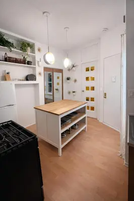 a kitchen with a island with a wooden counter top at Cozy Little Italy Retreat Steps from SoHo in New York