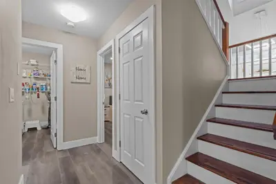 a hallway with a white door and stairs at Evergreen Villa Poconos - Hot Tub, Fire Pit, Close to Kalahari, Great Wolf Lodge and Camelback in Tobyhanna