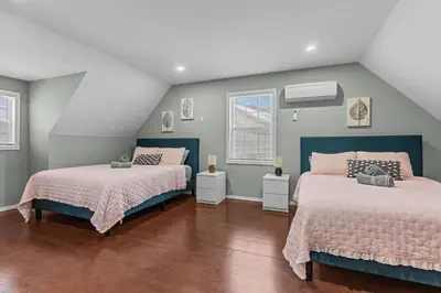 two beds in a room with two windows at Evergreen Villa Poconos - Hot Tub, Fire Pit, Close to Kalahari, Great Wolf Lodge and Camelback in Tobyhanna