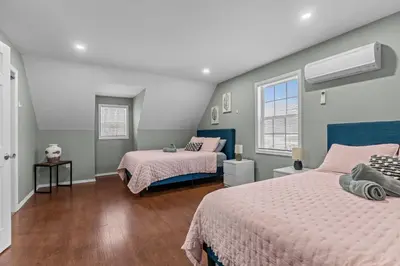 a bedroom with two beds and two windows at Evergreen Villa Poconos - Hot Tub, Fire Pit, Close to Kalahari, Great Wolf Lodge and Camelback in Tobyhanna