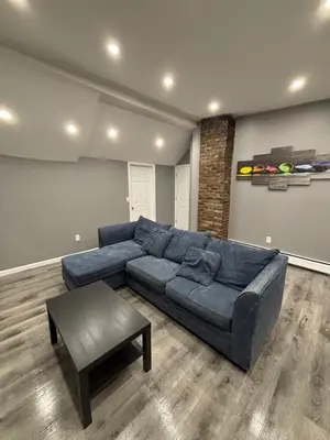 a living room with a blue couch and a table at The loft 2 bedroom apartment in Newark