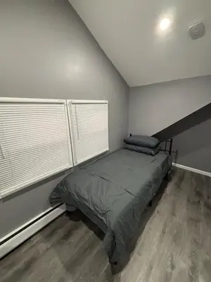 a bedroom with a bed and two windows at The loft 2 bedroom apartment in Newark