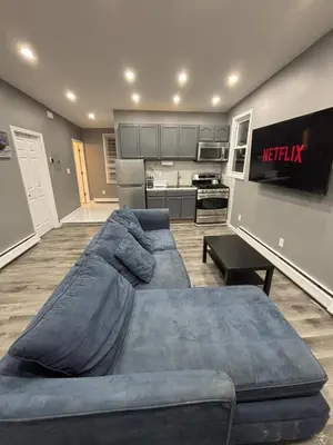 a living room with a couch and a kitchen at The loft 2 bedroom apartment in Newark