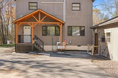 a house with a garage with a wooden roof at Lakefront with Beach Game Room Fire-pit and More in Blakeslee