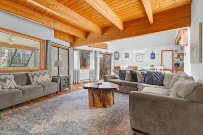 a living room with couches and a wooden ceiling at Lakefront with Beach Game Room Fire-pit and More in Blakeslee