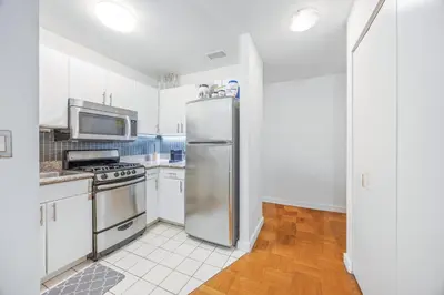 a kitchen with a stainless steel refrigerator at Chelsea 1BR in Shared Apt with Laundry and Rooftop in New York