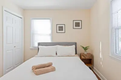 a bedroom with a white bed with two towels on it at Charming Entire Home,18m to Manhattan, Home Theater in Carlstadt