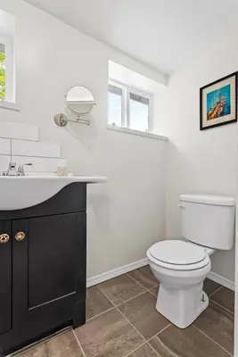 a white bathroom with a toilet and a sink at Country Chic 3BR Retreat Near All Star Village in Treadwell
