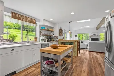 a kitchen with white cabinets and a wooden counter top at Country Chic 3BR Retreat Near All Star Village in Treadwell