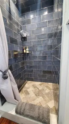 a bathroom with a shower with blue tiles at Waterfront Getaway in Historic Bristol in Bristol