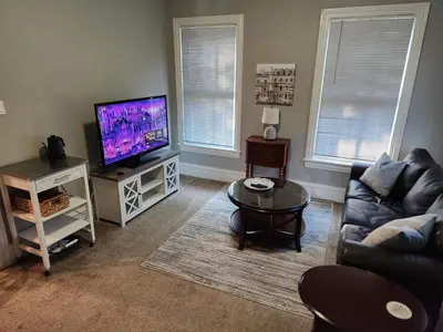 a living room with a couch and a flat screen tv at Waterfront Getaway in Historic Bristol in Bristol